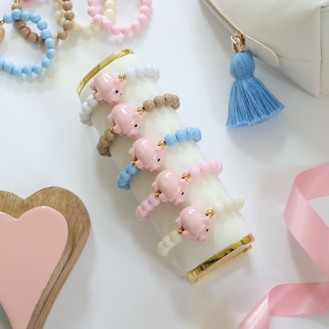 Beaded bracelet in a choice of 5 pastel colours. Featuring a cute chunky pink pig & gold spacer beads. Handmade stretch bracelet, the perfect gift for girls, teens & adults.