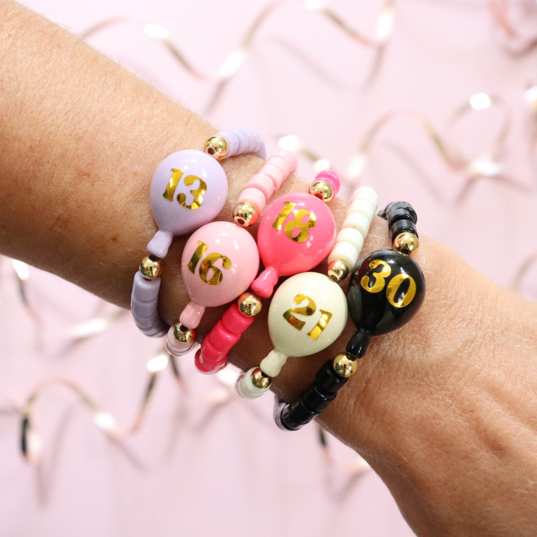 Beaded bracelet in a choice of 5 colours. Featuring a cute balloon bead personalised in gold with your choice of age. Handmade stretch bracelet, the perfect birthday gift for girls, teens & adults.